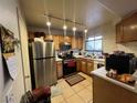 Efficient kitchen featuring stainless steel appliances, wood cabinets, and tile floors at 4555 E Sahara Ave # 166, Las Vegas, NV 89104