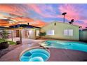 Backyard pool and spa with adjacent covered patio, palm trees, and beautiful desert sunset at 4623 Kearney St, Las Vegas, NV 89147