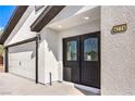 The front of the home features a two-car garage and stylish front doors with decorative glass and the house number at 4774 San Sebastian Ave, Las Vegas, NV 89121