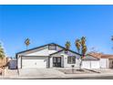 Charming single-story home featuring a two-car garage, palm trees, desert landscaping, and a white stucco facade at 4774 San Sebastian Ave, Las Vegas, NV 89121