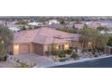 Beautiful single-story home featuring a three-car garage, stone details, and desert landscaping at 5410 Serenity Brook Dr, Las Vegas, NV 89149