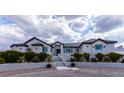 Elegant home exterior featuring manicured landscaping, stone accents, and a welcoming entrance with a paved walkway and stairs at 5865 Egan Crest Dr, Las Vegas, NV 89149