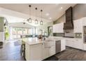 Bright kitchen with a large island, farmhouse sink, stainless steel appliances, and open layout to the living area at 5865 Egan Crest Dr, Las Vegas, NV 89149