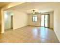 A bright living room with tile floors, a ceiling fan, and access to the backyard at 7253 Blooming Jasmine Ave, Las Vegas, NV 89117