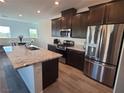 Modern kitchen featuring granite countertops, stainless steel appliances, and wood flooring at 7334 N Decatur Blvd # 6, Las Vegas, NV 89131