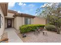 Inviting front entrance with decorative door, tiled patio and garden seating at 7452 Chaffinch St, North Las Vegas, NV 89084