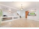 Bright living room with tile flooring, chandelier, and modern staircase at 810 Socorro Song Ln, Henderson, NV 89052