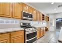 Kitchen featuring stainless steel appliances, wood cabinets, light countertops, and backyard access at 9785 Gallo Dr, Las Vegas, NV 89147