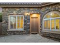 Inviting front entrance with stone accents, arched window and doorway, and a neutral-colored front door at 11763 Kingsland Ave, Las Vegas, NV 89138