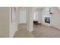 Neutral-toned living room featuring a fireplace, arched doorways, modern furniture, and bright natural light at 11763 Kingsland Ave, Las Vegas, NV 89138
