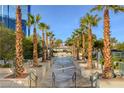 Outdoor pool area lined with tall palm trees, decorative planters, and stone pathway leading to a resort style oasis at 125 E Harmon Ave # 1620, Las Vegas, NV 89109