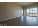 Open-concept living room featuring large windows, neutral walls, and hardwood floors at 150 N Las Vegas Blvd # 2302, Las Vegas, NV 89101