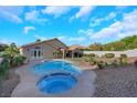 A backyard featuring a private pool, spa, landscaped garden, and a covered patio, perfect for outdoor living at 1594 Pontine Ct, Henderson, NV 89052