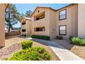 Two-story tan apartment buildings with well-maintained landscaping, offering a welcoming outdoor view for residents at 2451 N Rainbow Blvd # 1016, Las Vegas, NV 89108