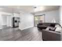 Bright living room boasts gray wood-look flooring, a neutral sectional couch, and sliding glass door to a patio at 2451 N Rainbow Blvd # 1016, Las Vegas, NV 89108