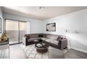 Comfortable living room features a large sectional sofa, decorative rug, and sliding glass door to outdoor balcony at 2451 N Rainbow Blvd # 1016, Las Vegas, NV 89108