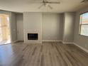 Cozy living room showcasing wood flooring, a fireplace, and backyard access at 258 Bella Matese Ave, Las Vegas, NV 89183