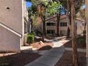 Exterior walkway surrounded by mature trees and landscaping between units at 3041 Casey Dr # 101, Las Vegas, NV 89120