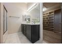 Bathroom with double vanity, modern fixtures, a large mirror, and a walk-in closet at 3409 Catherine Mermet Ave, North Las Vegas, NV 89081