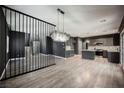 Open-concept living space features modern lighting, wood floors, and view of the kitchen and staircase at 3409 Catherine Mermet Ave, North Las Vegas, NV 89081