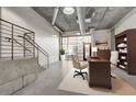Open living area features concrete floors, industrial ceilings, and a cozy workspace at 353 E Bonneville Ave # 181/281, Las Vegas, NV 89101