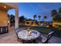 Outdoor patio with table overlooking a custom pool with rock waterfall and swim up bar at 382 Chaplin Cove Ave, Las Vegas, NV 89183