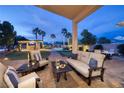 Covered outdoor patio with plush seating, a dining table, and views of the stunning pool area at 382 Chaplin Cove Ave, Las Vegas, NV 89183