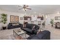 An open concept living room featuring dark sofas and bar seating at 4808 Straight Flush Dr # 103, Las Vegas, NV 89122