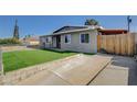 Quaint single-story home with a spacious driveway and chain-link fenced yard at 5409 Holmby Ave, Las Vegas, NV 89146