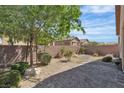 Private backyard with stone landscaping, rock features and a retaining wall at 6160 Majestic Wind Ave, Las Vegas, NV 89122