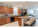 Spacious kitchen featuring wood cabinets, granite counters, stainless steel appliances and an island with bar seating at 6317 Highledge St, North Las Vegas, NV 89081