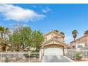 Two-story home with a red tile roof, white iron fence, arched entryway, and a well-maintained landscape at 6440 High Sierra Ave, Las Vegas, NV 89156
