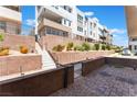 Multi-level home with landscaped terraces, brick retaining walls, and gated access to the upper levels at 647 Spotted Falcon St, Las Vegas, NV 89138