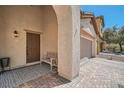 Inviting front porch with a bench and stylish rug by the front door at 7060 Seat Wall Rd, Las Vegas, NV 89148