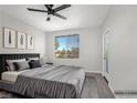 Virtually staged bedroom featuring large windows, a ceiling fan, and an exterior door at 913 Duckhorn Ct # 201, Las Vegas, NV 89144