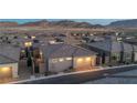 Rear view of a gray home with garage, small trees, and fenced in backyard in a residential area at 916 Belleforte Ln, Las Vegas, NV 89138
