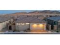 Home exterior with a two car garage, stone accents, and a private, fenced backyard at 916 Belleforte Ln, Las Vegas, NV 89138