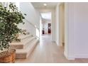 Bright foyer featuring hardwood floors, staircase, and a plant adding a touch of nature at 953 Wagner Valley St, Henderson, NV 89052