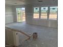 Bright, unfinished living room featuring sliding glass doors and multiple windows, awaiting customization at 9548 Hinson St, Las Vegas, NV 89139