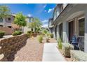 Landscaped walkway leads to the townhome entrance, featuring decorative rock, retaining wall and well-maintained bushes at 965 Nevada State Dr # 35101, Henderson, NV 89002
