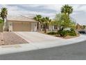 Charming single-story home featuring desert landscaping, a tile roof, and a spacious driveway leading to a two-car garage at 2212 Marble Gorge Dr, Las Vegas, NV 89117