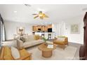 Bright living room features neutral furniture, a ceiling fan, and an open floor plan to the kitchen at 3528 Tack St, Las Vegas, NV 89122
