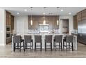 Spacious open kitchen with gray cabinets, a large island with seating, and modern stainless steel appliances at 7477 Triple Knot Ct, Las Vegas, NV 89113