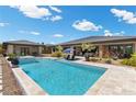 Stunning backyard oasis with sparkling pool, spa, covered patio, and lush landscaping at 7477 Triple Knot Ct, Las Vegas, NV 89113