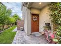 Inviting front porch with a decorated door, a trellis with greenery and a whimsical bicycle decor at 7788 Ebro Valley Ct, Las Vegas, NV 89113