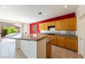 Cozy kitchen with a red accent wall and breakfast bar that opens to a slider door at 853 Ashford Way, Henderson, NV 89015