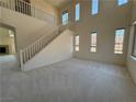 Open floor plan with high ceilings and staircase features natural light and neutral carpet at 853 Ashford Way, Henderson, NV 89015