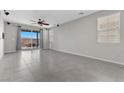 A spacious living room with tile flooring, ceiling fan, and sliding glass doors to the outside patio at 2293 Teatro Ave, Henderson, NV 89044
