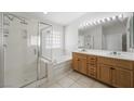 Bathroom featuring a double vanity, walk-in shower, and tub, providing a spa-like experience at 315 Barletta Ave, Las Vegas, NV 89123