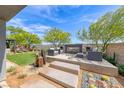 Elegant backyard with modern outdoor seating around a contemporary fireplace and lush greenery at 109 Reverie Heights Ave, Henderson, NV 89011